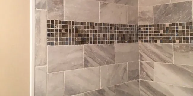 Close-up of gray marble-look tile with a mosaic border