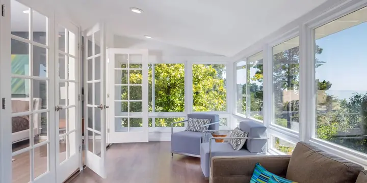 Sunroom with French doors and a wall of large windows